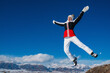 © chaossart - Happy woman tourist jumping on mountains background in winter