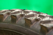 detail of a black bicycle tire with fur on the surface. green background.