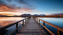 A Vertical Video Showing A Wooden Passage Over A Small Lake That Is Reflective And A Mountain Range On The Horizon