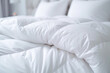 white duvet lying on the background of the headboard with pillows,close-up,the concept of preparing for the winter season,household chores,comfort in the house,hotel and home textiles