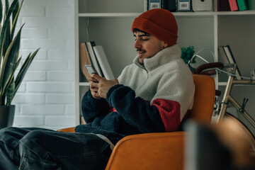 Sticker - young man at home with mobile phone warm