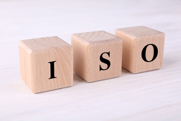 International Organization for Standardization. Cubes with abbreviation ISO on white wooden table, closeup