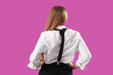 Wall Mural - Stylish young woman with suspenders on purple background, back view