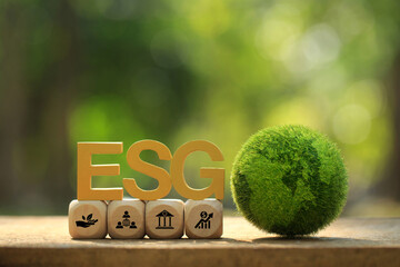 Wall Mural - ESG environmental social governance business strategy investing concept.ESG text and icons on a wooden cube with Green earth on green background.Business Investment Strategy. ESG Fund. Business trend.