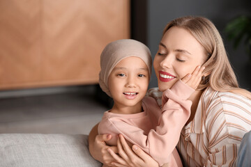 Wall Mural - Little Asian girl after chemotherapy with her mother hugging at home, closeup