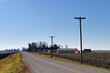 An empty stretch of a country road lined with American flags attached telephone poles that parallel the route. 