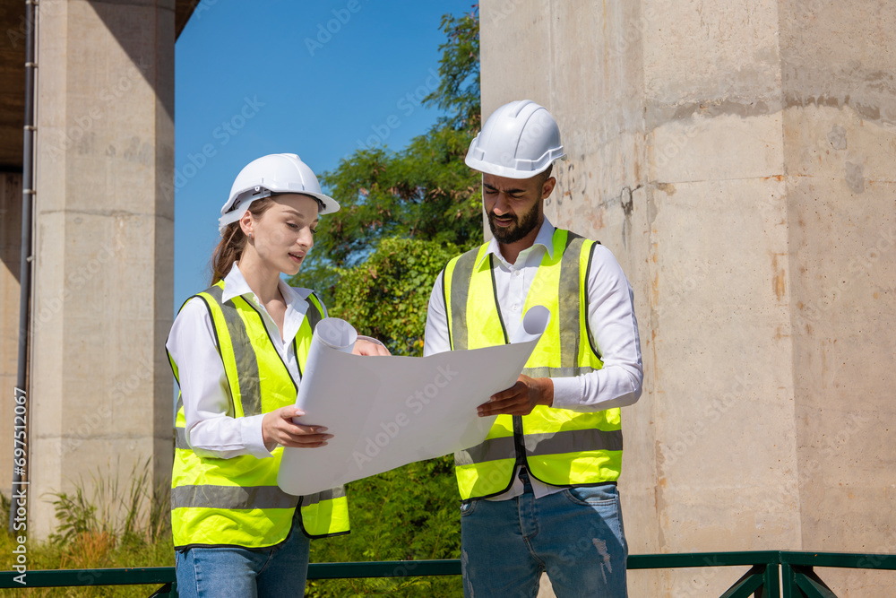 Middle Eastern male foreman and Caucasian female engineer holding ...
