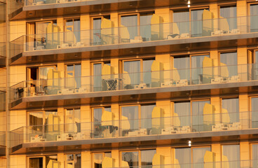 Glass windows on a multi-story building as an abstract background. Texture. Sunse