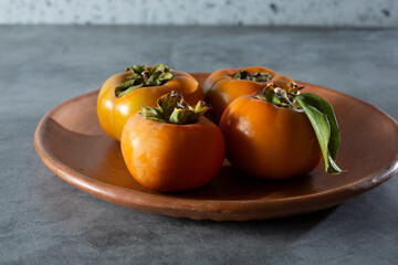 Canvas Print - A view of a plate of fuyu persimmons.