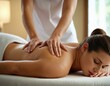 © burntime555 - Woman lying on a massage table receiving a relaxing back massage, with the hands of the masseuse visible.