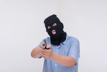 A scary and unhinged evil robber pointing a gun threatening to shoot. Commanding at gunpoint. Isolated on a white backdrop.