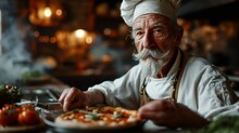 Old Italian Chef With Grey Moustache, Wearing Chefs Hat On His Head, Dish With Pizza In His Hands, Blurry Interior Of Kitchen At The Background A Delicious Piping Hot Pizza. Copy Space.