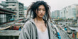 Rebellious Chinese teenager with long messy hair  stands on edge of building roof overlooking the gloomy city below, grey hoodie and white oversized t-shirt, beautiful face with minimal make-up.