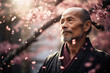 Senior Japanese man with sakura flower petals in the park.