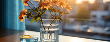 Wide Panoramic Pfacebook Banner Photo Of A Flower Vas And A Clear Glass Of Water Near A Window With Beautiful Flower Bunch And Blurred Background On A Cozy Hotel Bedroom Table    