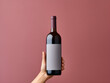 Wine bottle mockup with a hand holding a bottle of red wine