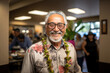 A smiling senior man wearing glasses and a traditional Hawaiian lei in a social gathering at a restaurant.