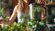 Young woman with a blender and green vegetables making detox shake or smoothie at home