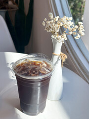 Ice Americano coffee in a bowl of plastic on the table at the cafe.