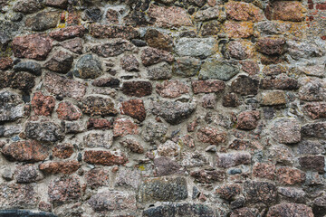 Wall Mural - A stone background made of cobblestones, an ancient wall, a road lined