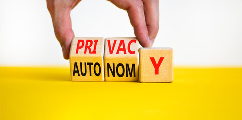 Wall Mural - Privacy or autonomy symbol. Concept word Privacy or Autonomy on wooden cubes. Beautiful yellow table white background. Businessman hand. Business privacy or autonomy concept. Copy space.