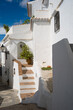 Escalera de acceso a casa encalada en color blanco en pueblo andaluz de Frigiliana (Málaga) en un día soleado de verano