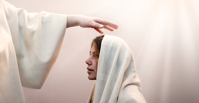 Blessing hand above the head of a woman in a headscarf