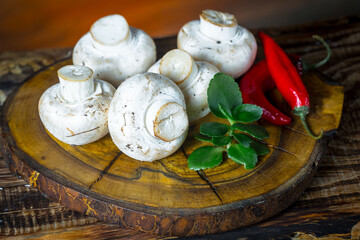 Champignon mushrooms in composition with food ingredients on old background