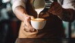 Barista pouring milk to create latte art for coffeehouse marketing