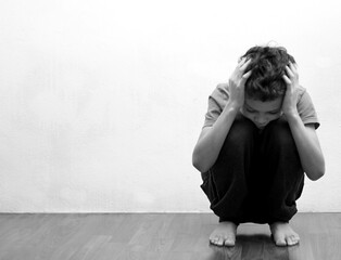 Wall Mural - boy praying in poverty on the floor stock image with no help crying alone and all by himself on white background stock photo 