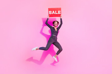 Poster - Full length photo of cute excited lady wear glamour overall jumping rising sale card empty space isolated pink color background