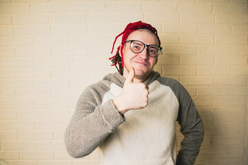 young man with a red dreadlocks on his head and glasses shows thumbs up