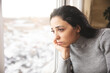 © ARAMYAN - Sad woman standing in front of the window