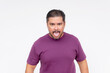 An inept and childish male sticking his tongue out, staring at the camera. Making a mockery of himself. Wearing a purple waffle shirt. Isolated on a white background.