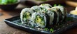Rice and avocado maki sushi roll served on a black plate in traditional Japanese cuisine.