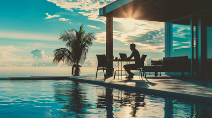 man working on her laptop computer sitting at poolside