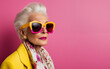 © Анастасия Бутко - Portrait of mature senior woman in stylish outfit and sunglasses on color pink background