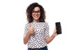 © Ivan Traimak - young curly secretary woman dressed in summer blouse with polka dot pattern holding smartphone with mockup