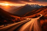 Fototapeta Niebo - Winding road in the mountains at sunset, stretching into the distance 