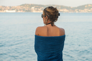 A woman wrapped in a blue towel after swimming