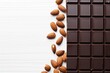 Top view dark chocolate and whole almond nut on white background, copy space.