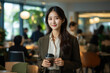 © vefimov - Woman is seen holding cup of coffee in restaurant. This image can be used to depict relaxing coffee break or cozy atmosphere in cafe.