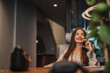 © qunica.com - Confident woman having phone call with client during phone call while working alone at modern office in the city center.