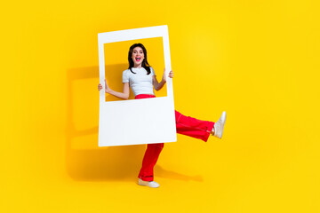 Canvas Print - Full length photo of cool impressed woman dressed white t-shirt holding paper photo frame empty space isolated yellow color background