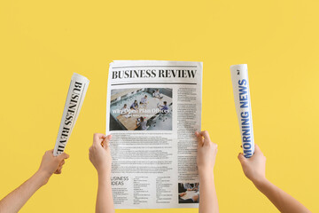 Wall Mural - Women with newspapers on yellow background