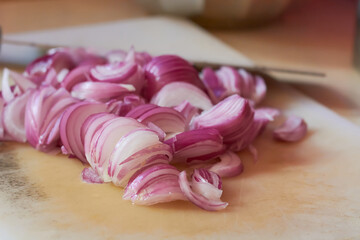 Wall Mural - close-up of chopped or sliced red onion on cutting board, fresh flavored vegetable ingredient for cooking, selective focus with copy space