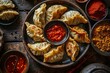 A plate of dumplings with a bowl of sauce.