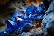 A close-up of a rock with blue crystals and a few pieces of blue glass.