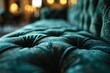 A blue velvet couch with a green cushion.