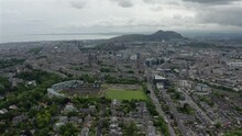 Scenic Drone Aerial Footage Of Edinburgh With Salisbury Crags On Arthurs Seat In Background, Scotland